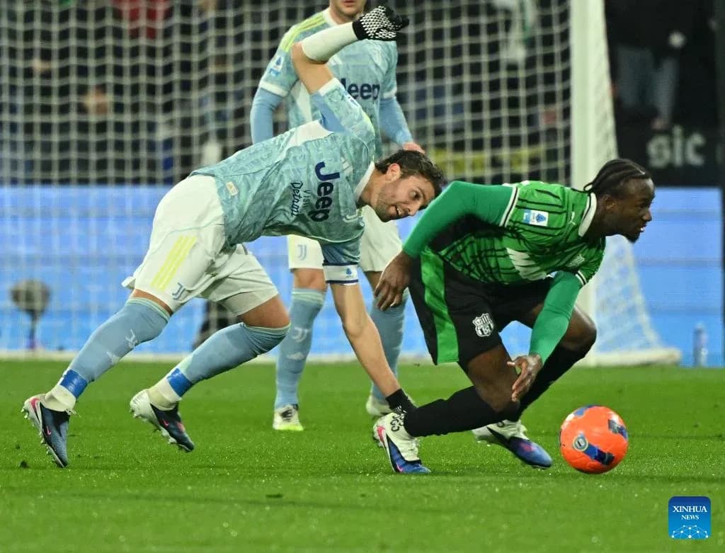 Juventus player tackles Sassuolo player during match Juventus player tackles Sassuolo player during match