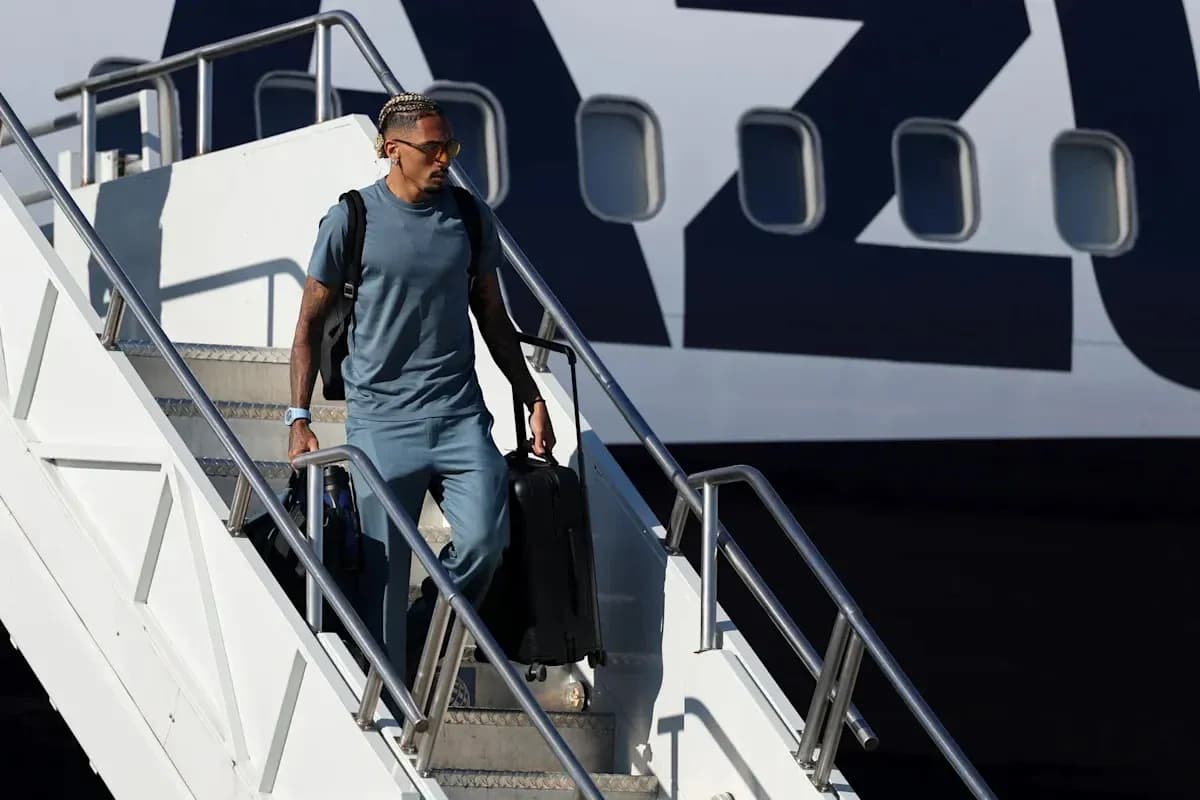Player exiting airplane with suitcase in hand Player exiting airplane with suitcase in hand