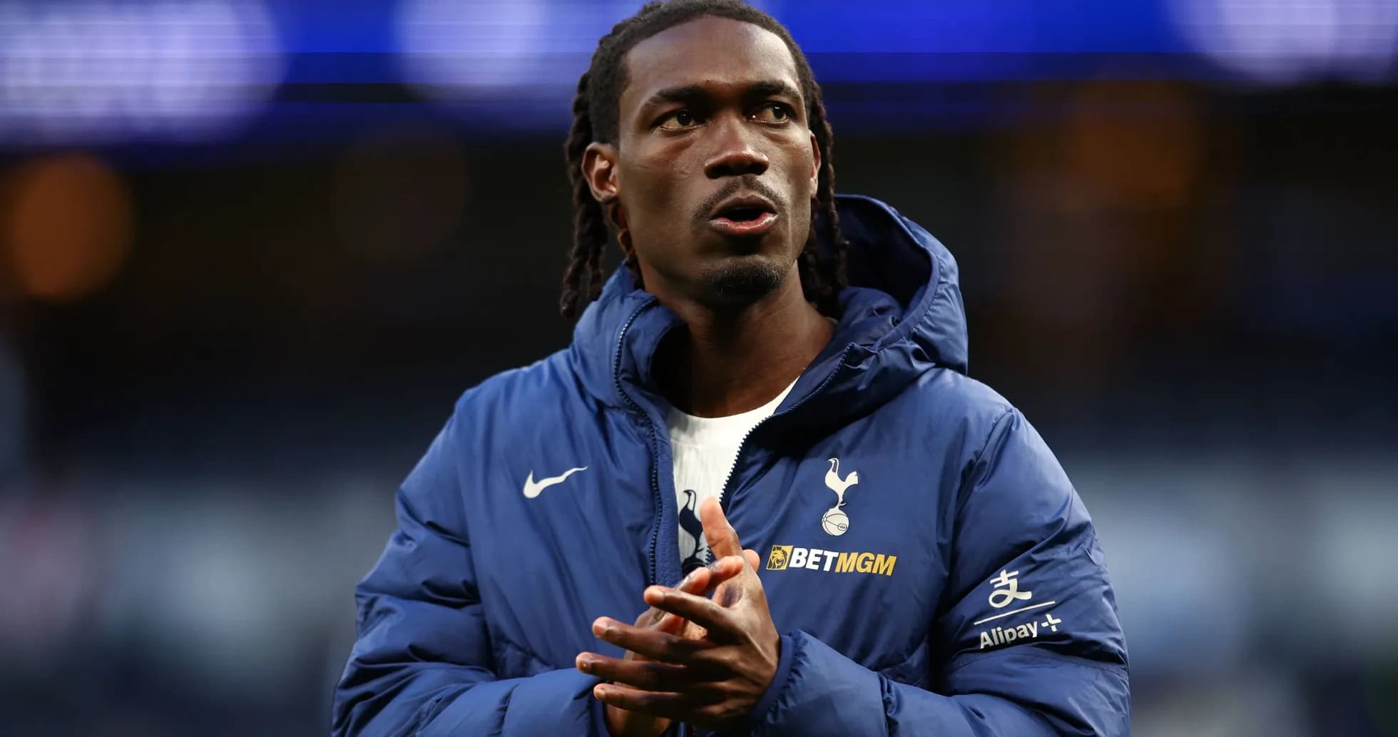 Player wearing Tottenham jacket on the field Player wearing Tottenham jacket on the field