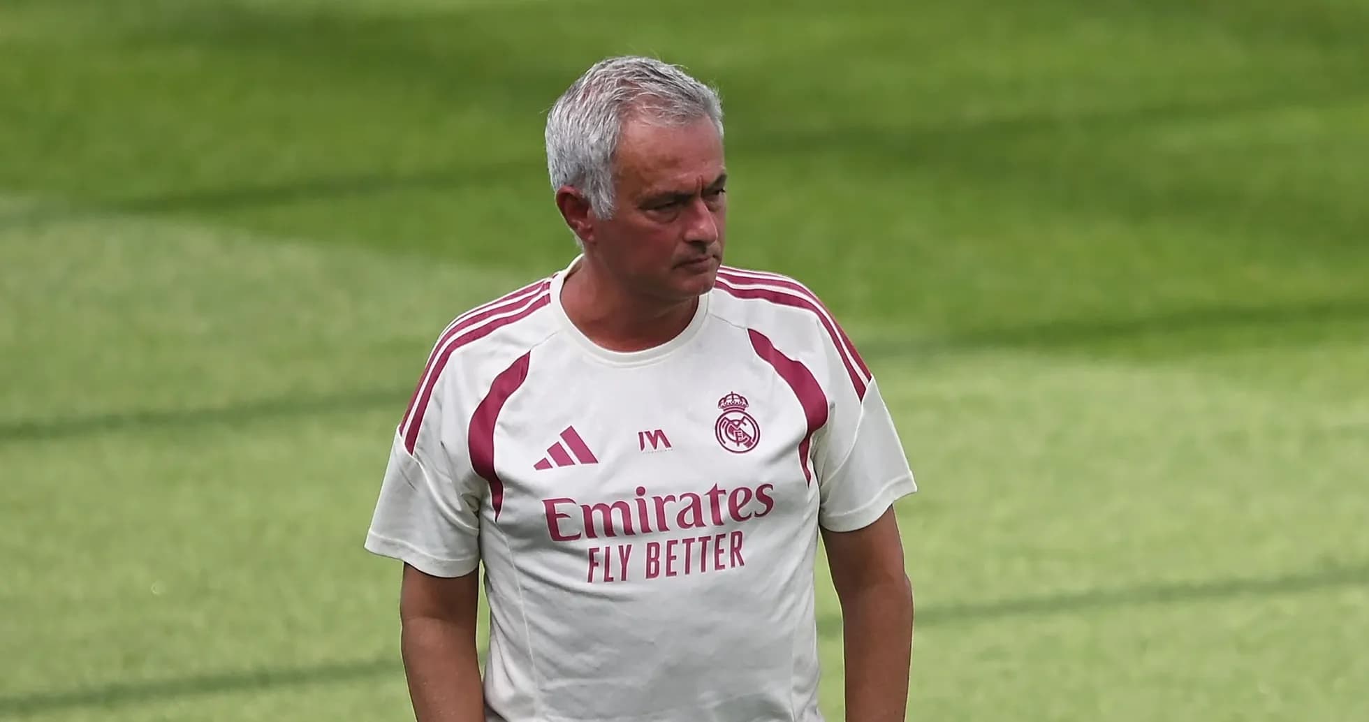 Manager walking on training pitch in club attire Manager walking on training pitch in club attire