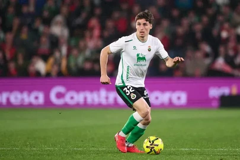 Player in green and white kit dribbling ball on pitch Player in green and white kit dribbling ball on pitch