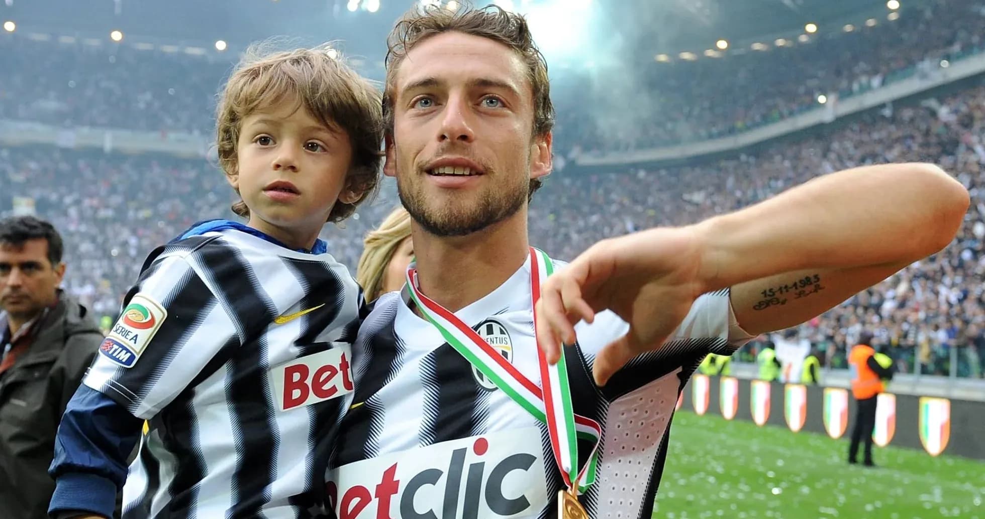 Player celebrating with child on the pitch Player celebrating with child on the pitch