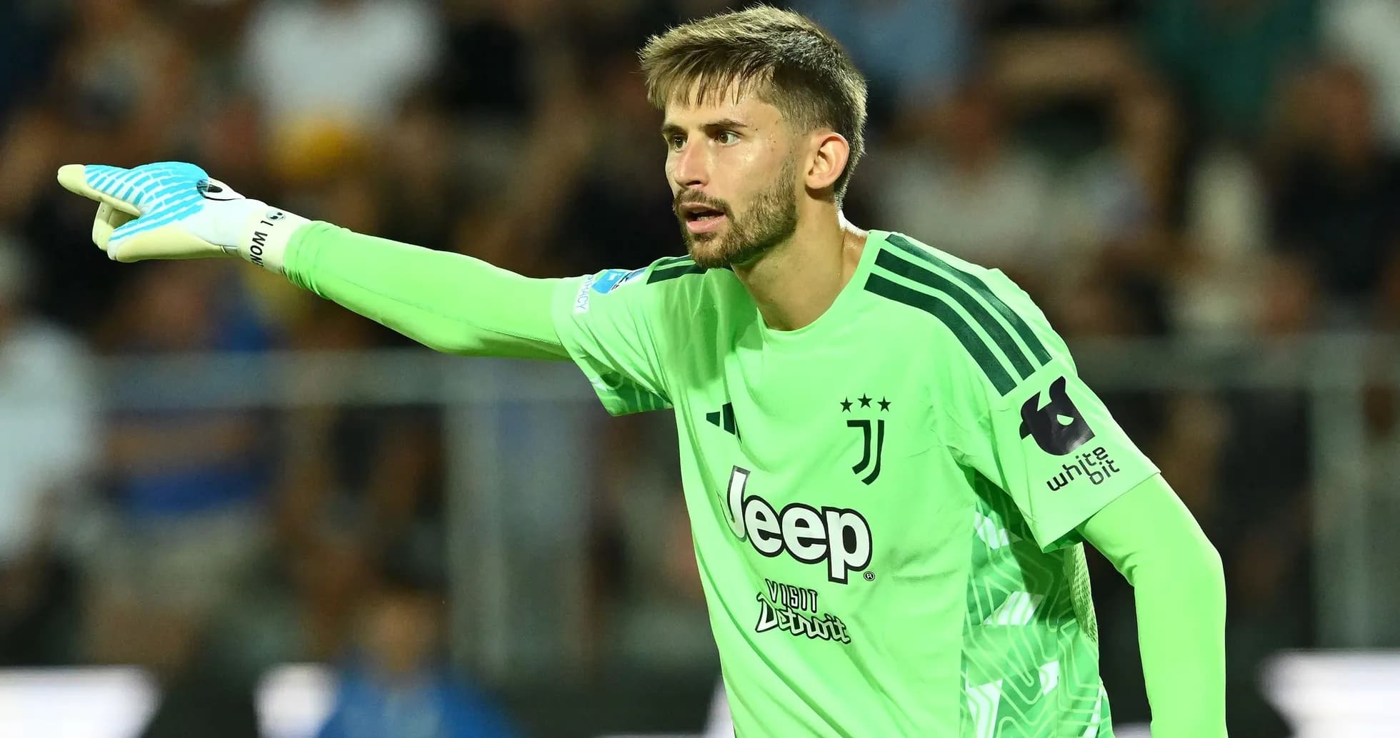 Goalkeeper in green kit directing teammates during match Goalkeeper in green kit directing teammates during match