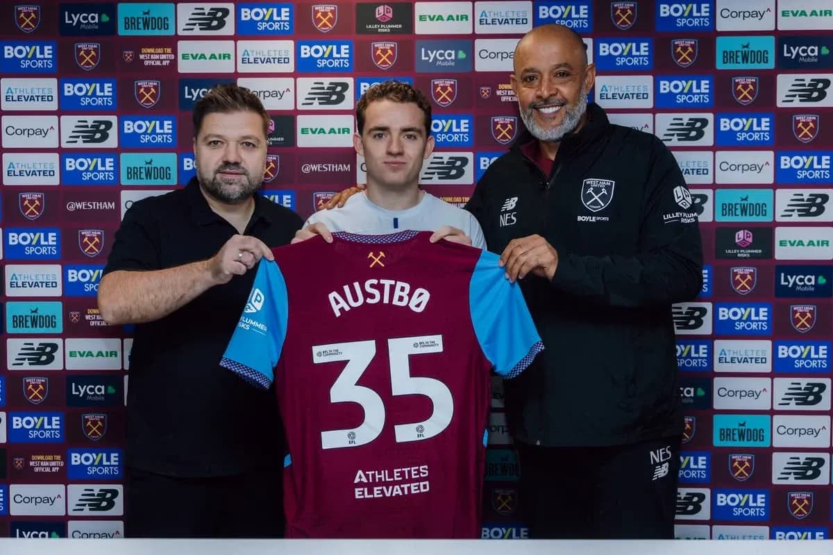 Player holding West Ham jersey with staff members Player holding West Ham jersey with staff members