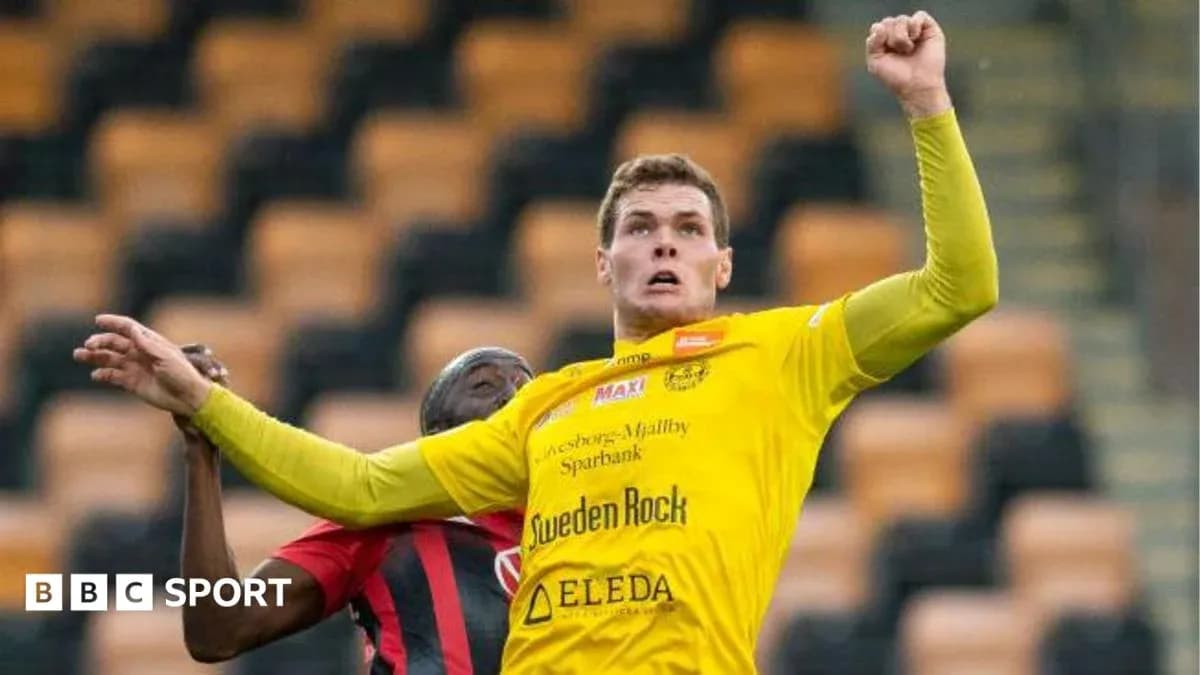 Player in yellow jersey competing for a header Player in yellow jersey competing for a header
