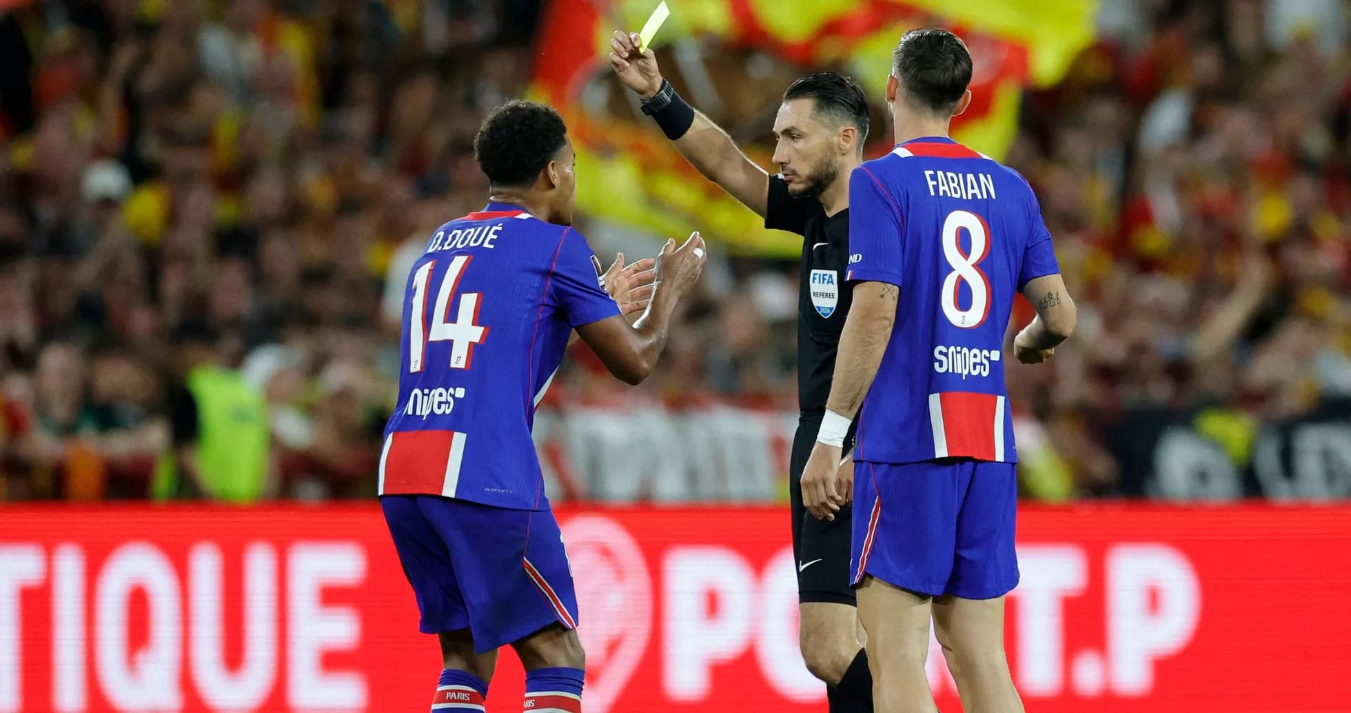 Referee showing yellow card to player on field Referee showing yellow card to player on field