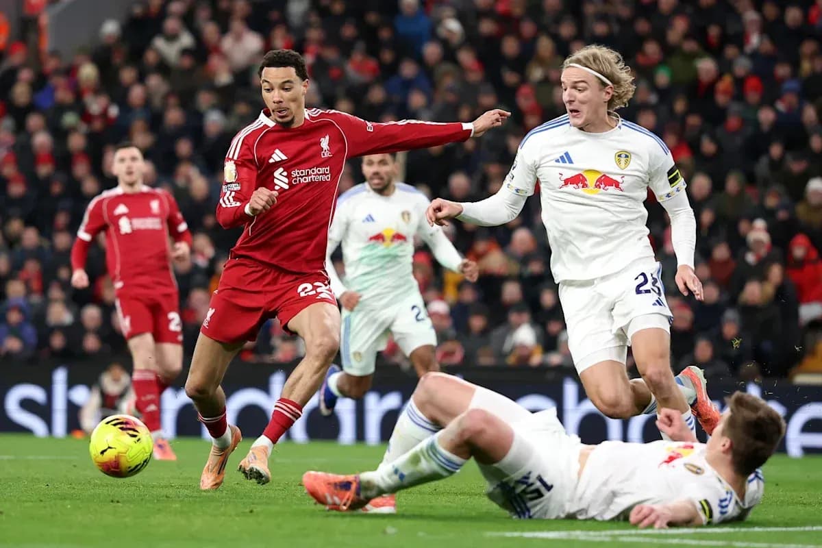 Liverpool player dribbling past Leeds opponents during match Liverpool player dribbling past Leeds opponents during match