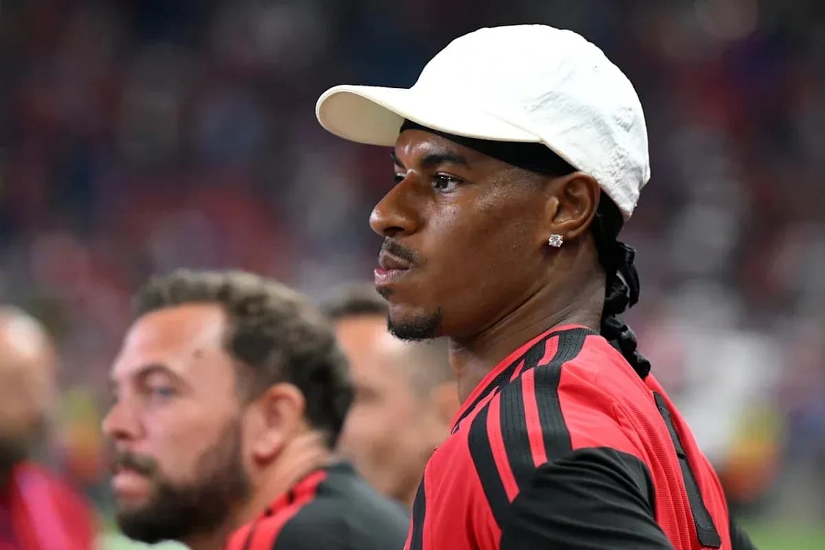 Player in red jersey and white cap on sidelines Player in red jersey and white cap on sidelines
