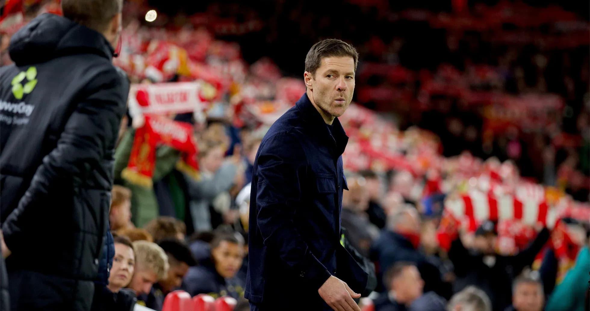 Coach observing fans holding team scarves in stadium Coach observing fans holding team scarves in stadium