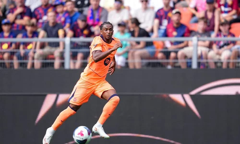 Player running during a football match with fans in background Player running during a football match with fans in background