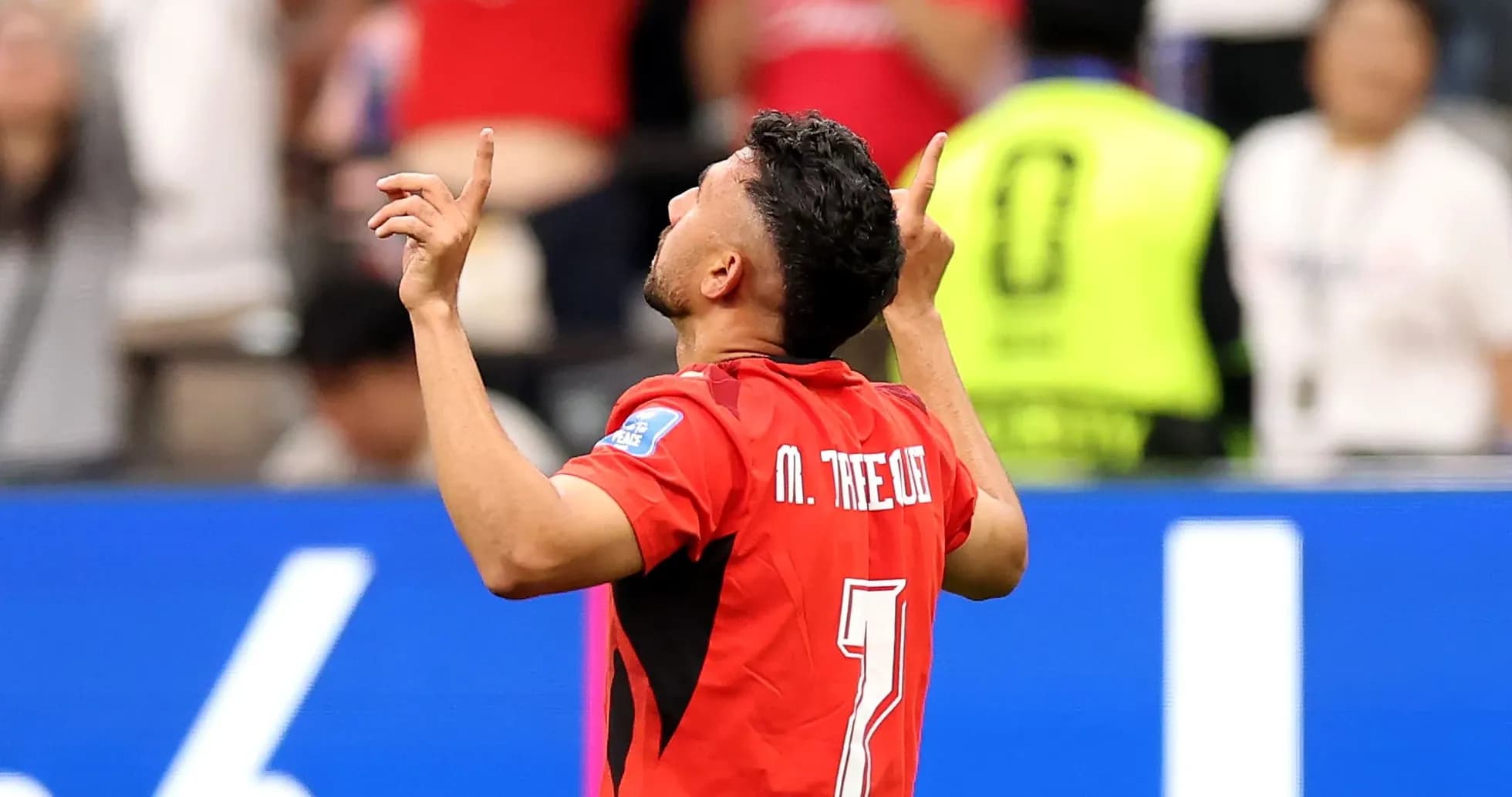 Player celebrating with arms raised after scoring Player celebrating with arms raised after scoring