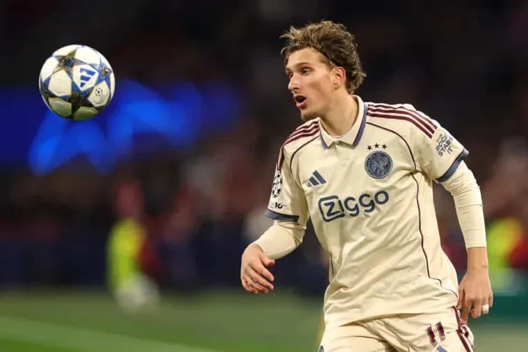Player in Ajax kit reacting to airborne ball Player in Ajax kit reacting to airborne ball
