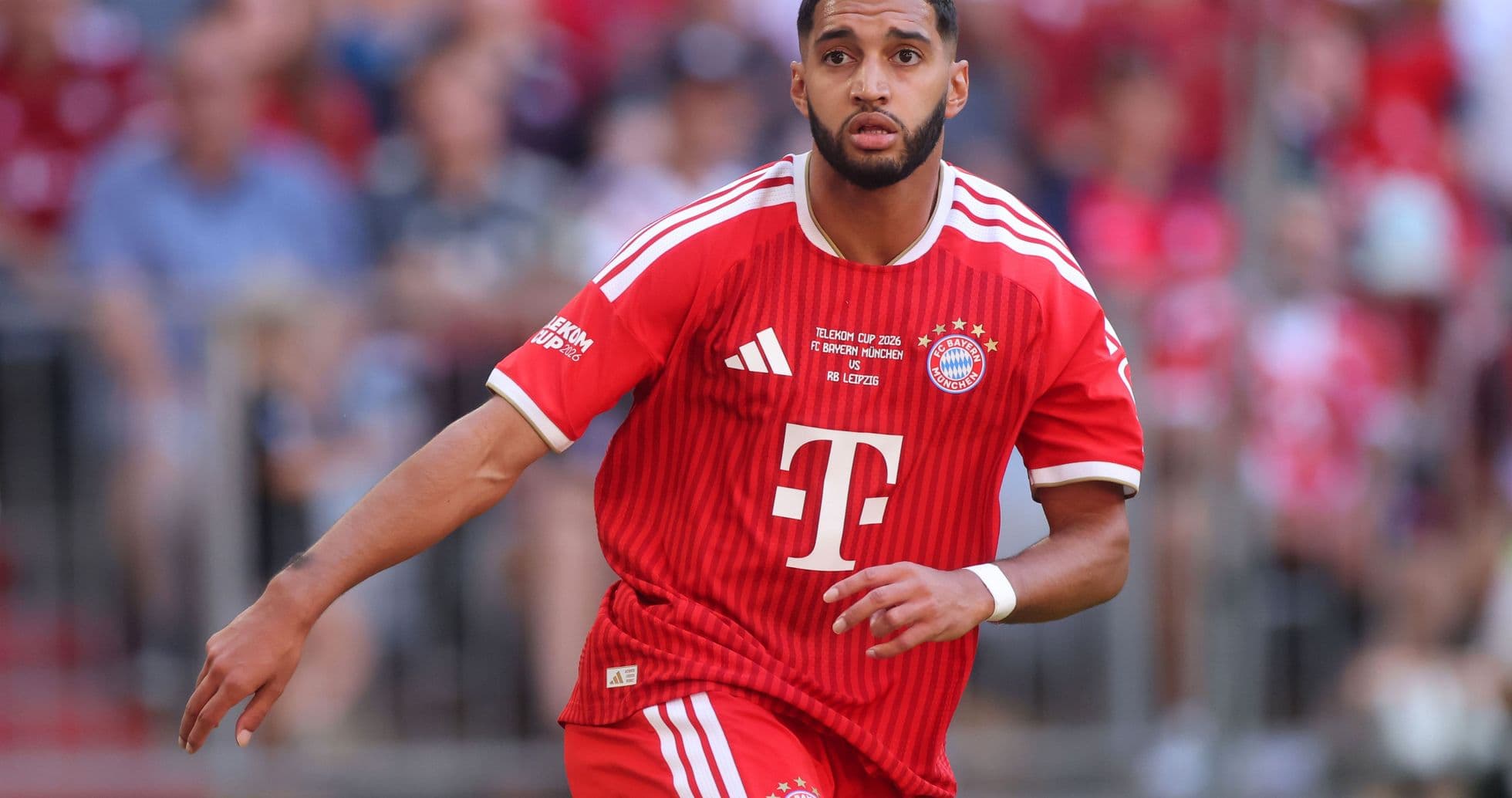 Player in red Bayern Munich jersey running on field Player in red Bayern Munich jersey running on field