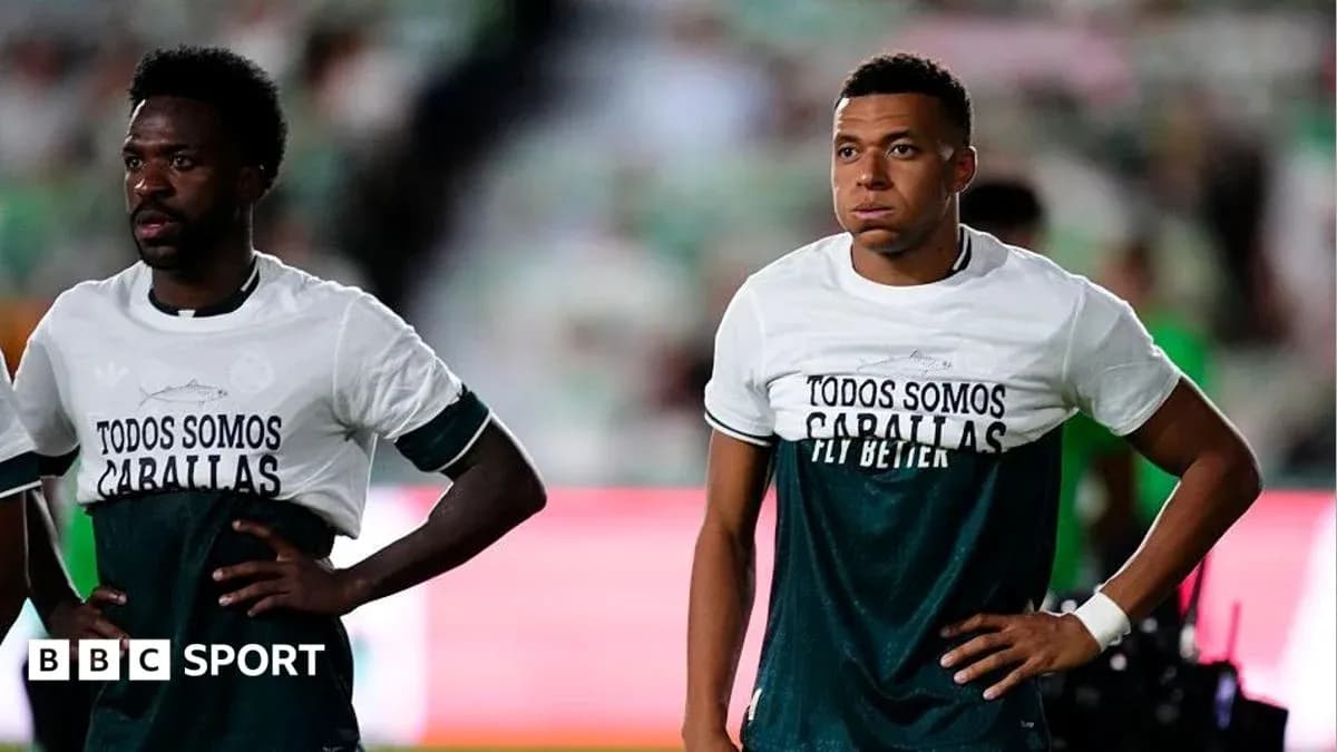 Two players wearing matching training shirts on pitch Two players wearing matching training shirts on pitch