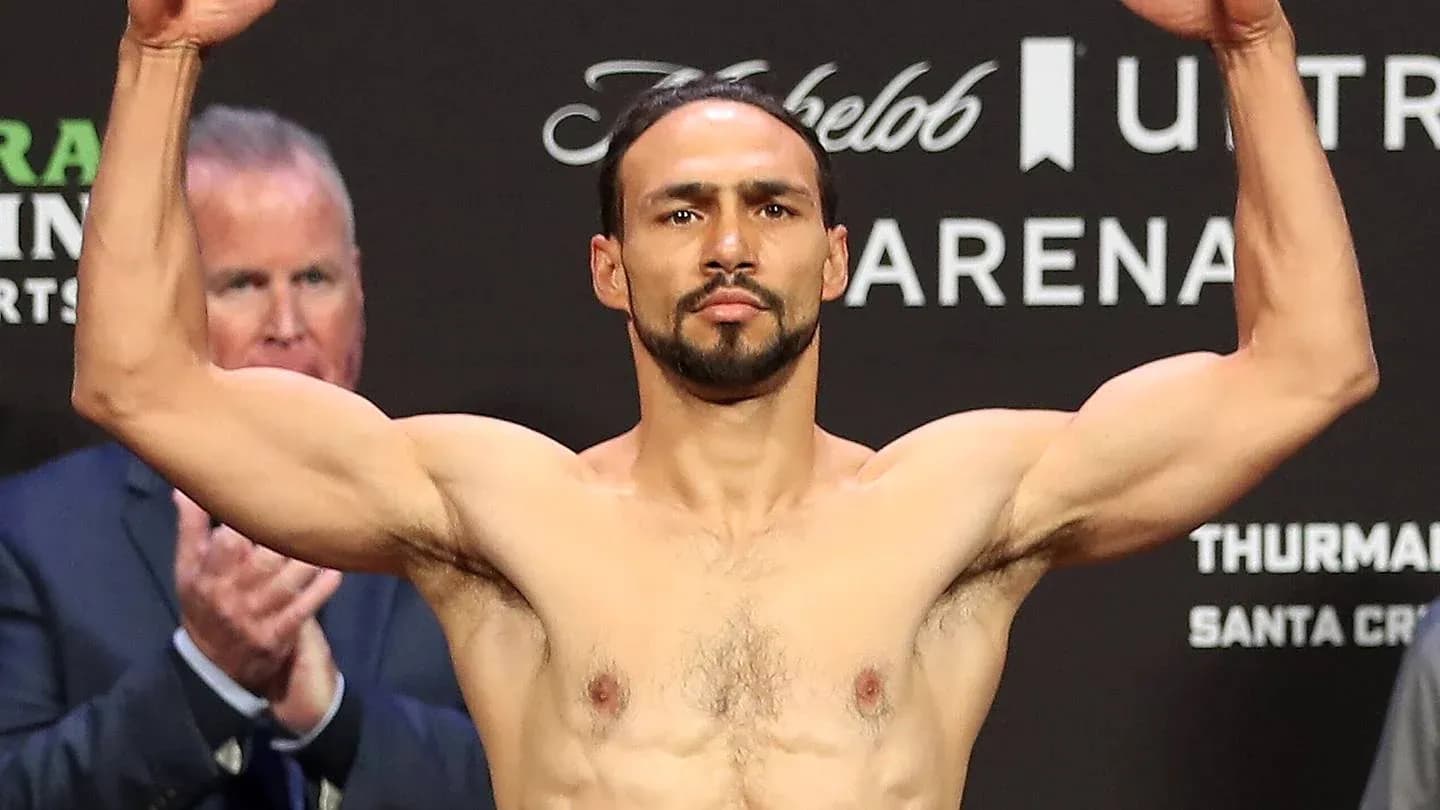 Fighter weighing in with arms raised at event Fighter weighing in with arms raised at event