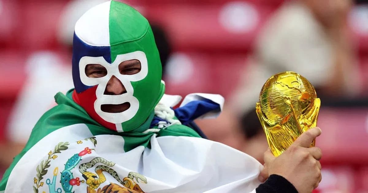 Fan wearing mask holding FIFA World Cup trophy Fan wearing mask holding FIFA World Cup trophy