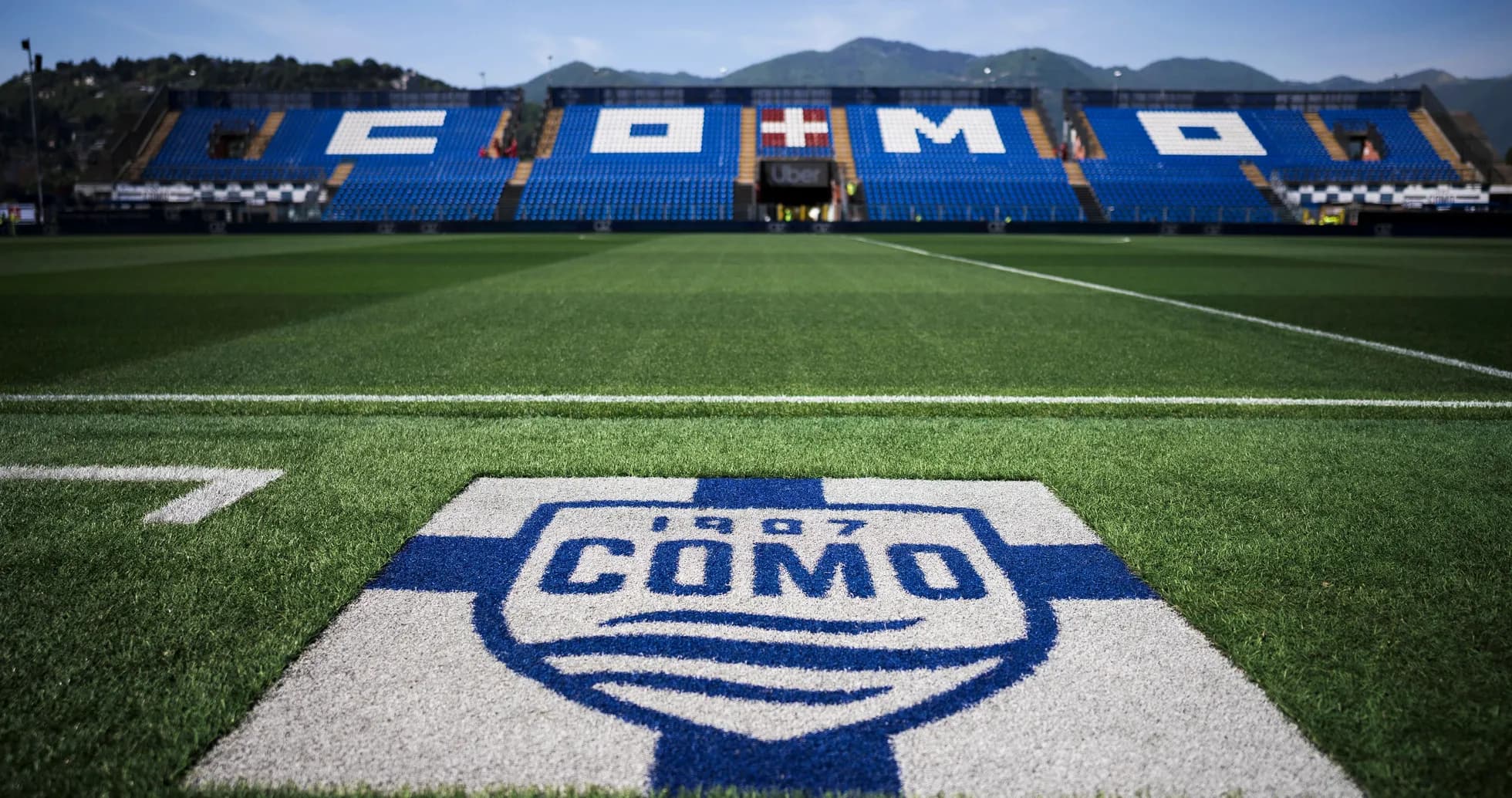 Como stadium field with team logo in foreground Como stadium field with team logo in foreground