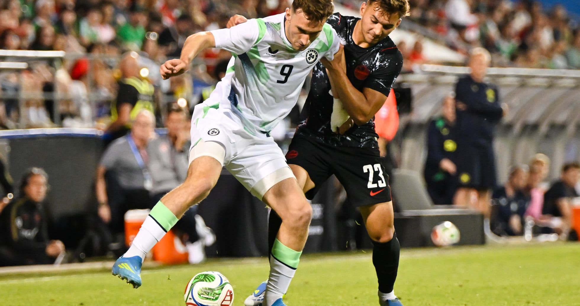 Two players competing for the ball during soccer match Two players competing for the ball during soccer match
