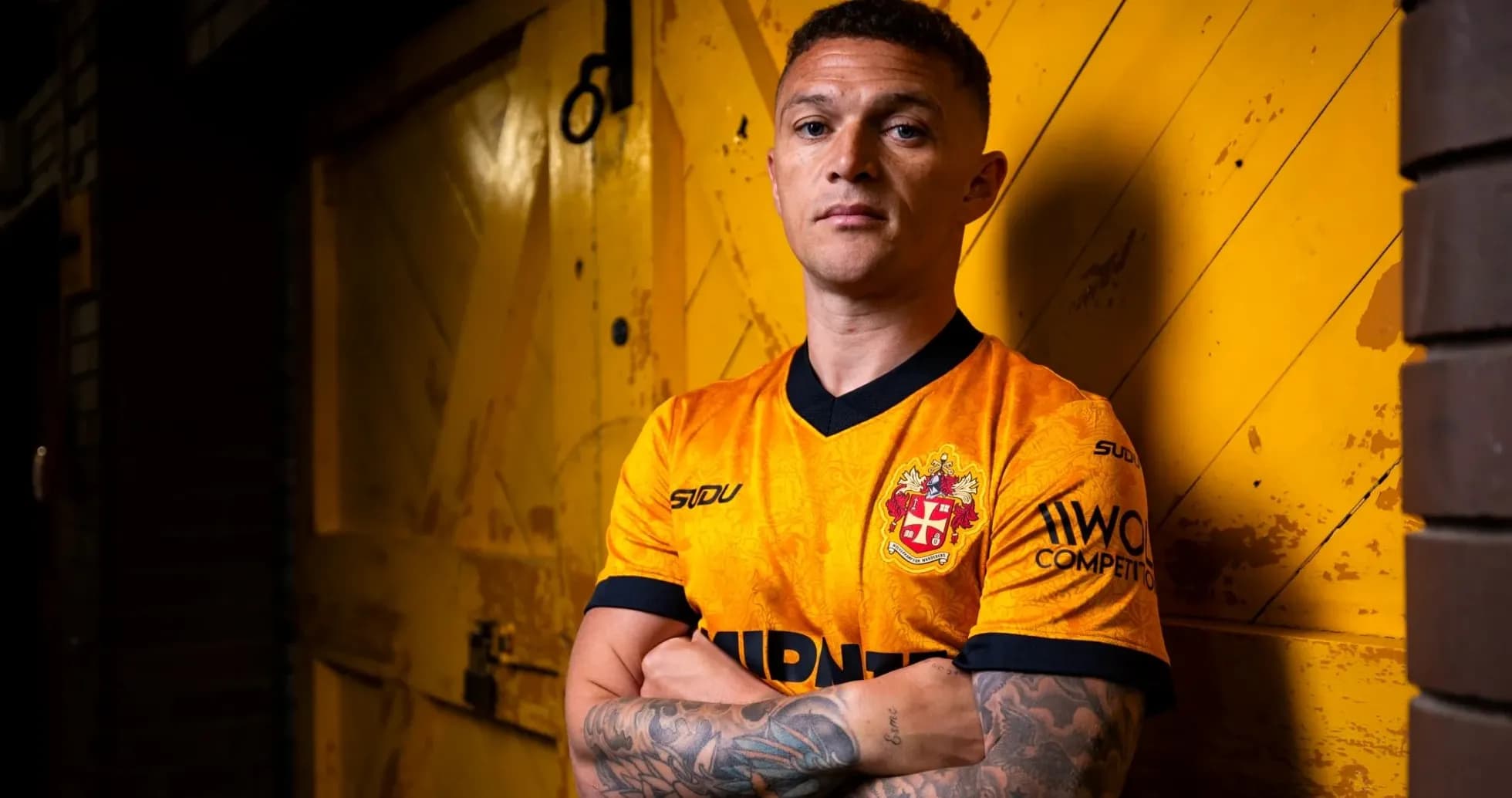 Player posing in orange team jersey against yellow backdrop Player posing in orange team jersey against yellow backdrop